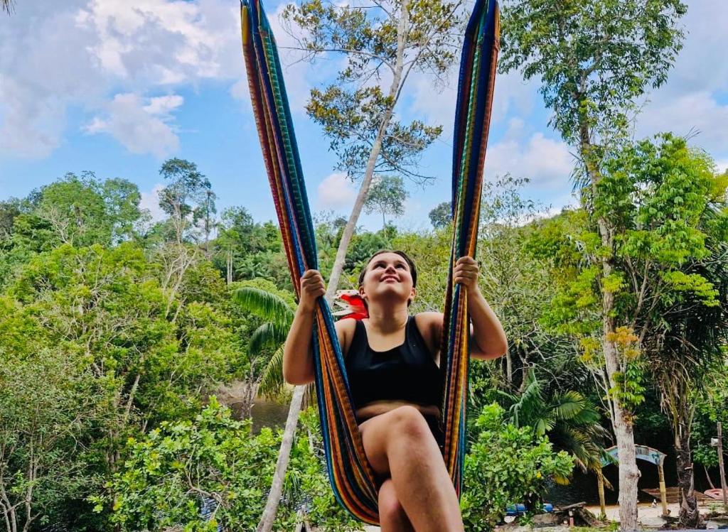 een vrouw zit op een touwschommel bij Refúgio na Floresta in Manaus