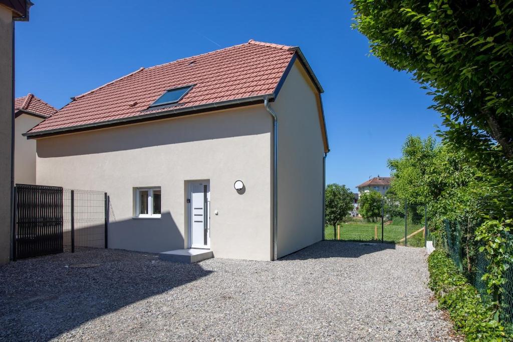 ein weißes Gebäude mit einem roten Dach in der Unterkunft Maison 3 chambres avec terrasse côté champ in Illfurth