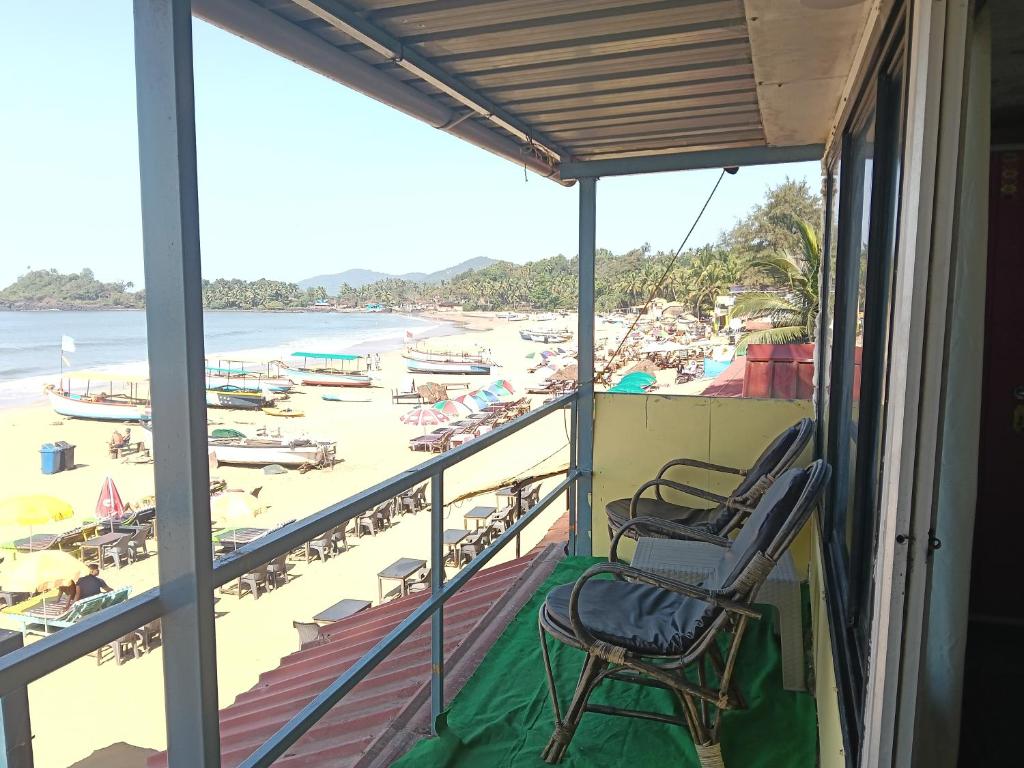 ein Balkon mit Blick auf den Strand in der Unterkunft Nirvana Beach Cottages in Canacona