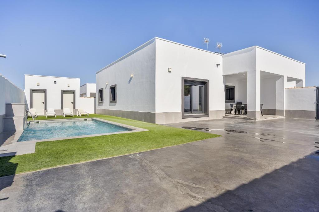 ein großes weißes Haus mit einem Pool in der Unterkunft Villa Infinity 1 in Chiclana de la Frontera