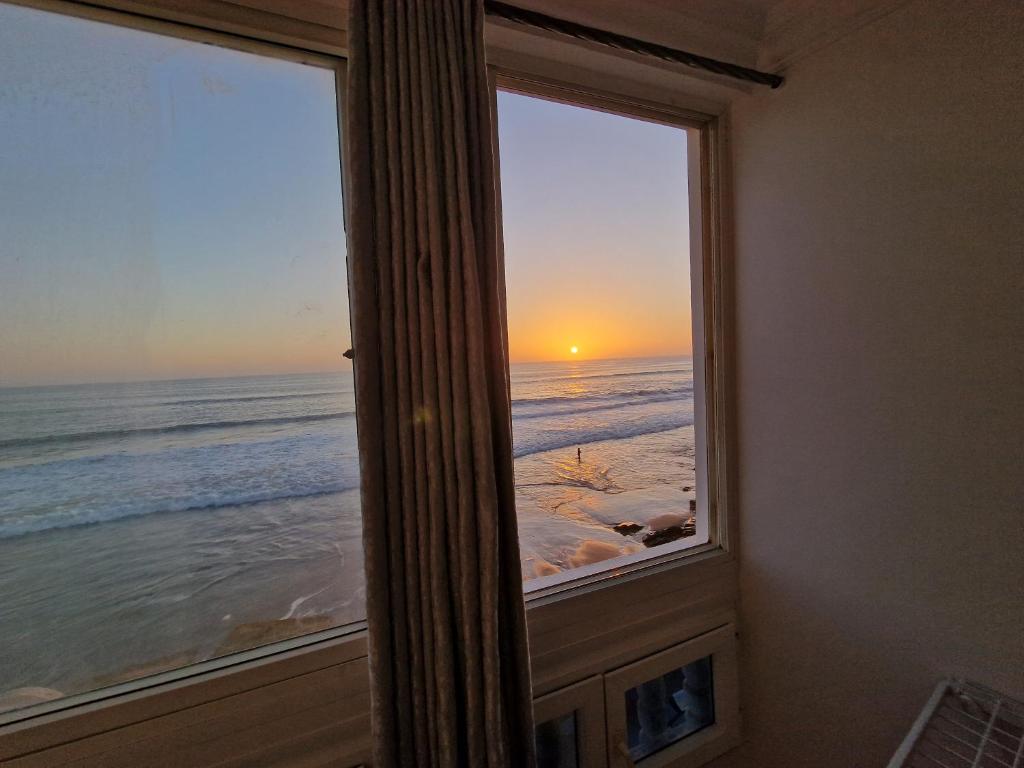 A vibrant rooftop terrace with seating overlooking the Taghazout coast.