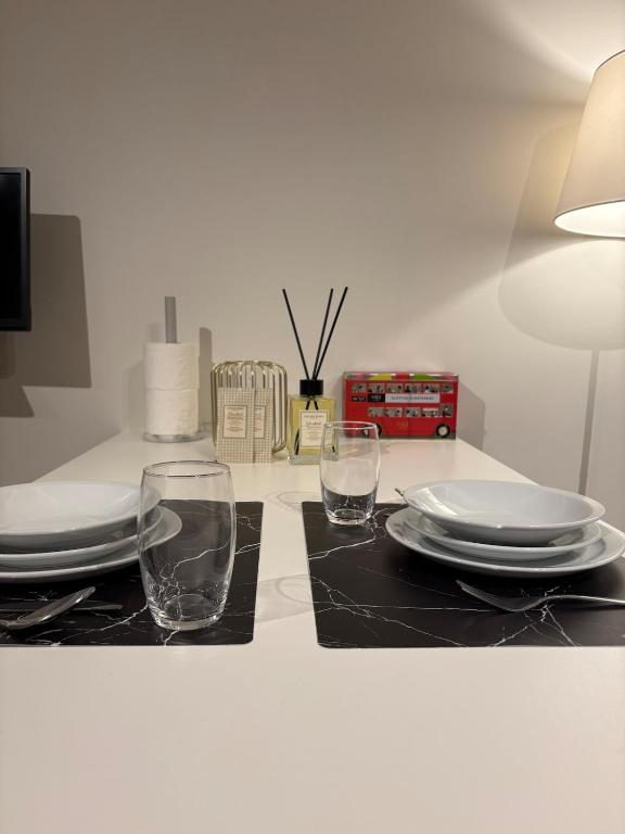 a table with two glasses and plates and a lamp at Briefstreet - Louvain in Leuven