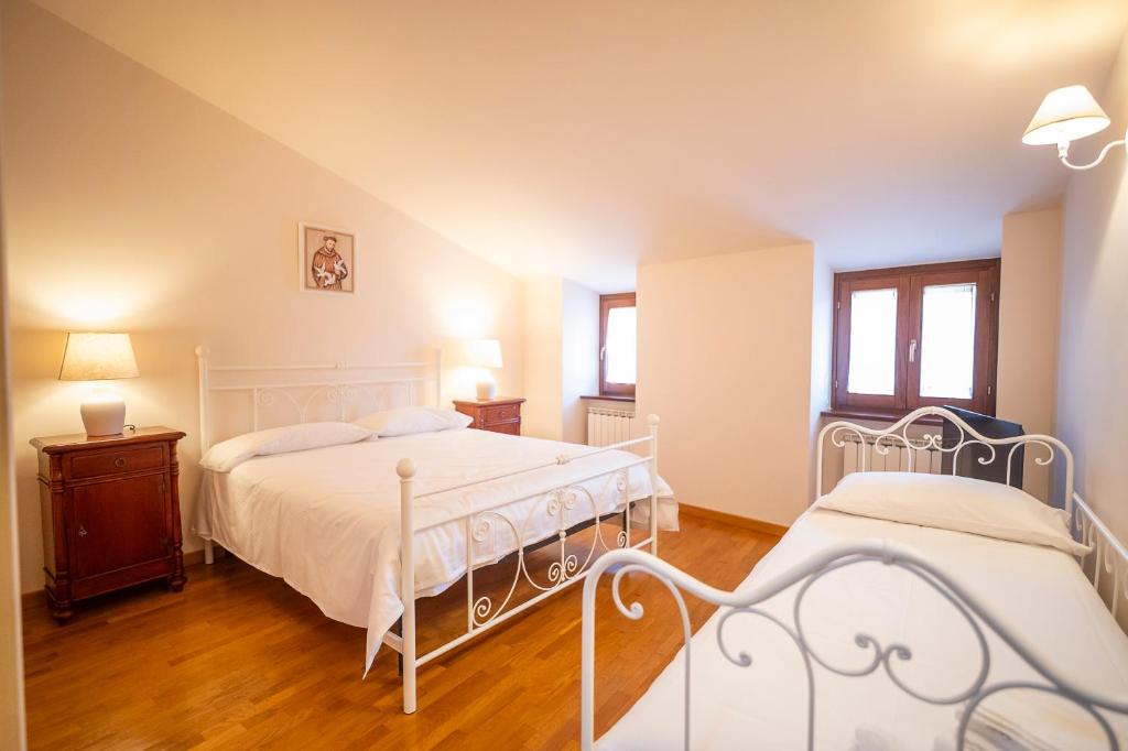 a bedroom with two beds and a wooden floor at La Torretta del Sementone in Assisi