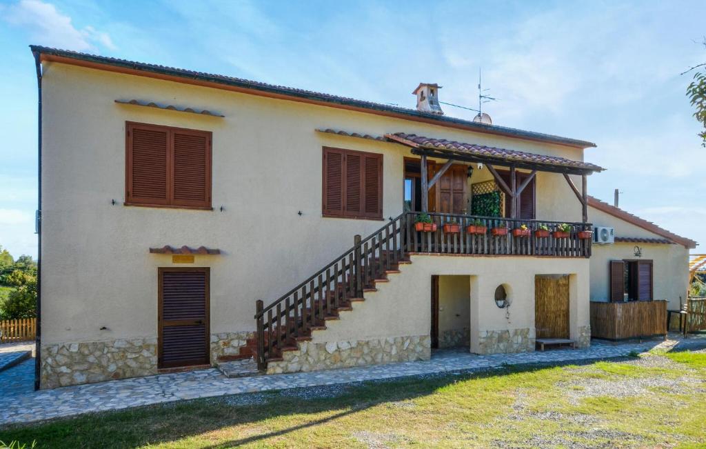 4 Bedroom Stunning Home In Roccastrada في روكاسترادا: منزل به درج وكلب على السطح