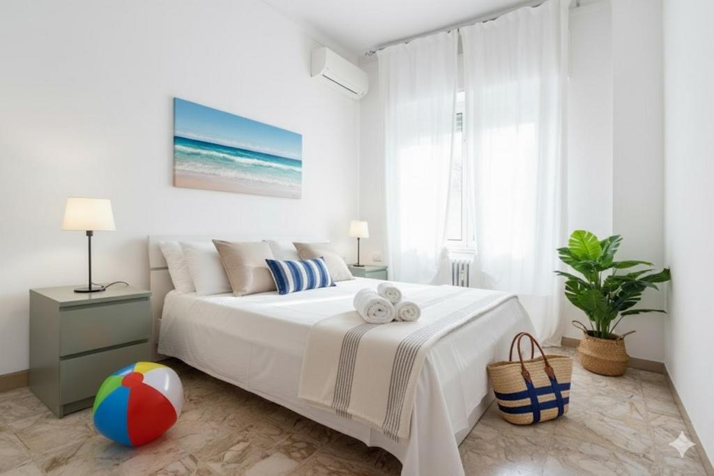 een witte slaapkamer met een bed en een strandbal bij Cycling Riviera apartment in Imperia