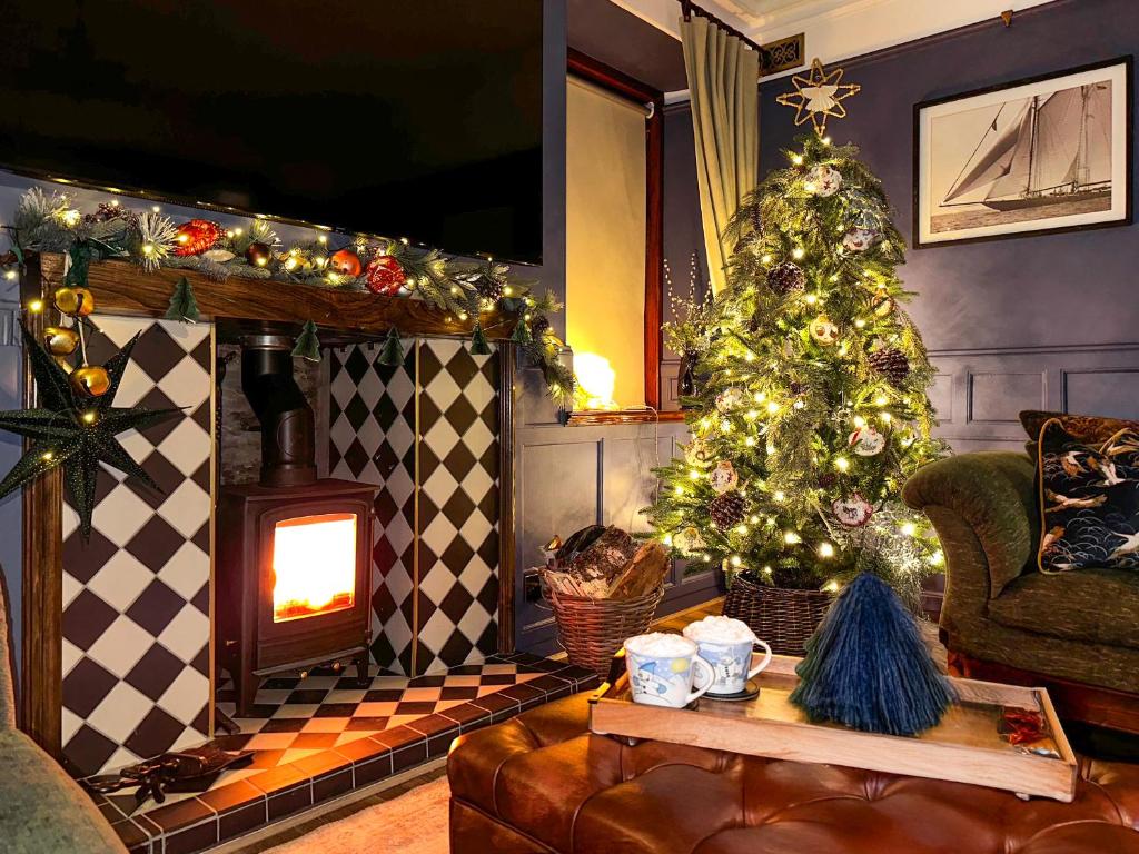 a living room with a christmas tree and a fireplace at Going Coastal in Inverallochy