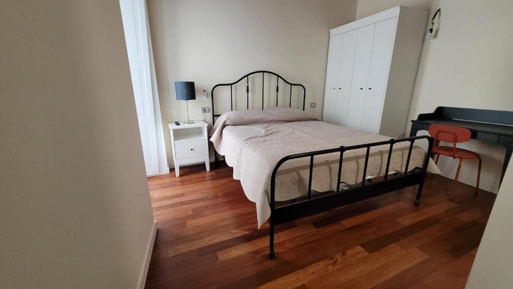 a bedroom with a bed and a wooden floor at Little Apartment in Potenza