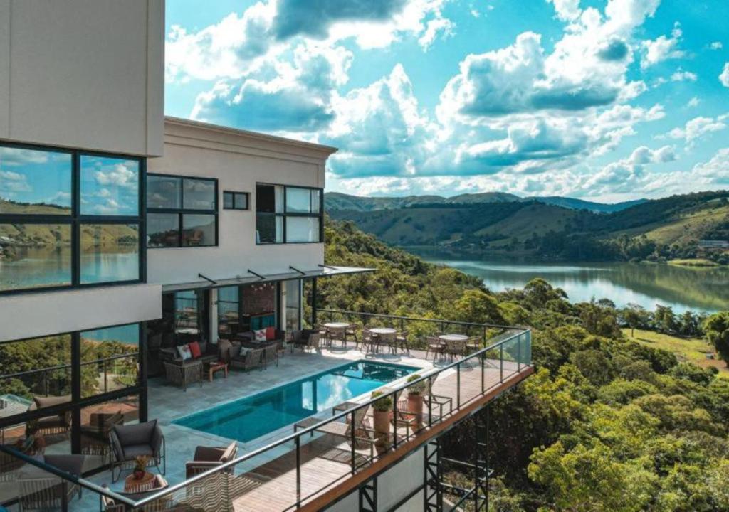een huis met een zwembad en uitzicht op een rivier bij Vista do Lago Hotel in Capitólio