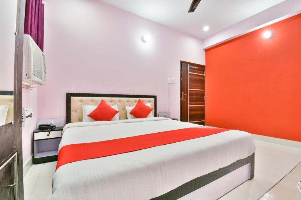 a bedroom with a large bed with a red wall at Magadh Imperial Guest House in Patna