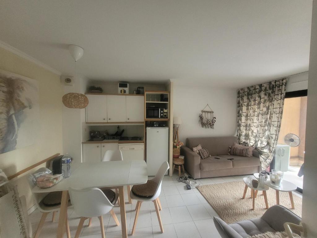 eine Küche und ein Wohnzimmer mit Tisch und Stühlen in der Unterkunft chambre dans une residence à deux pas de la mer in Cannes