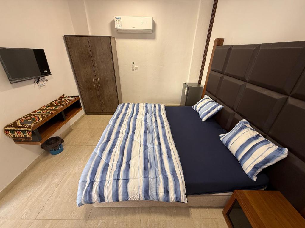 a bedroom with a large bed with a large headboard at Camel Dive Club By The Sea Inn in Jurf ad Darāwīsh