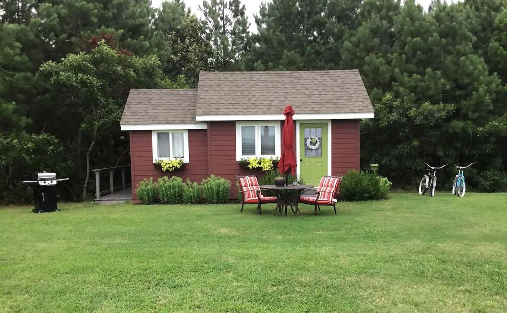 una pequeña casa con una mesa y sillas en el patio en Serene Tiny House with a Big Charm for Glamping in Virginia, en Accomac