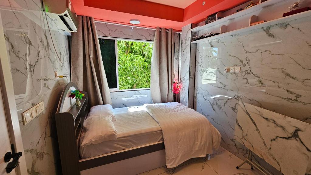 a small bed in a room with marble walls at Naseema Hiya - Central Ukulhas Residences in Ukulhas