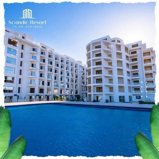 a swimming pool in front of two large buildings at غرفه فندقيه in Hurghada