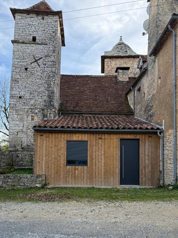 a building with a garage in front of a castle at Chez Vivi in Gindou