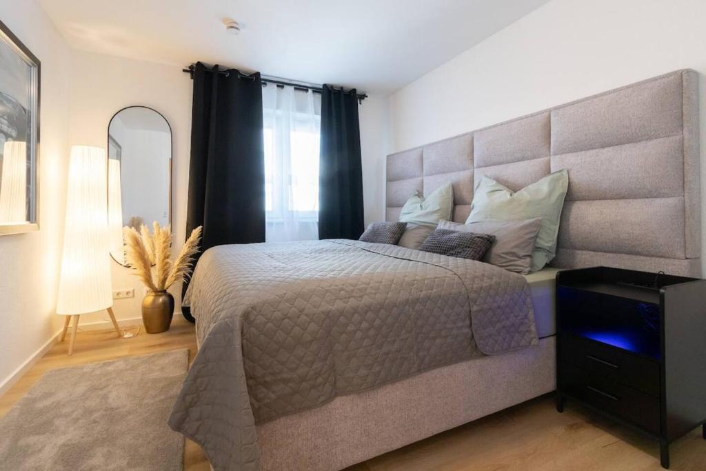 una camera da letto con un letto grande con una grande testiera di Stylish, cozy and natural apartment a Mendig