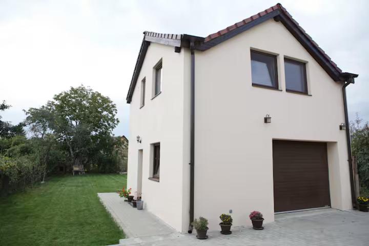 a white house with a garage and a yard at Transylvania Guest House in Făgăraş