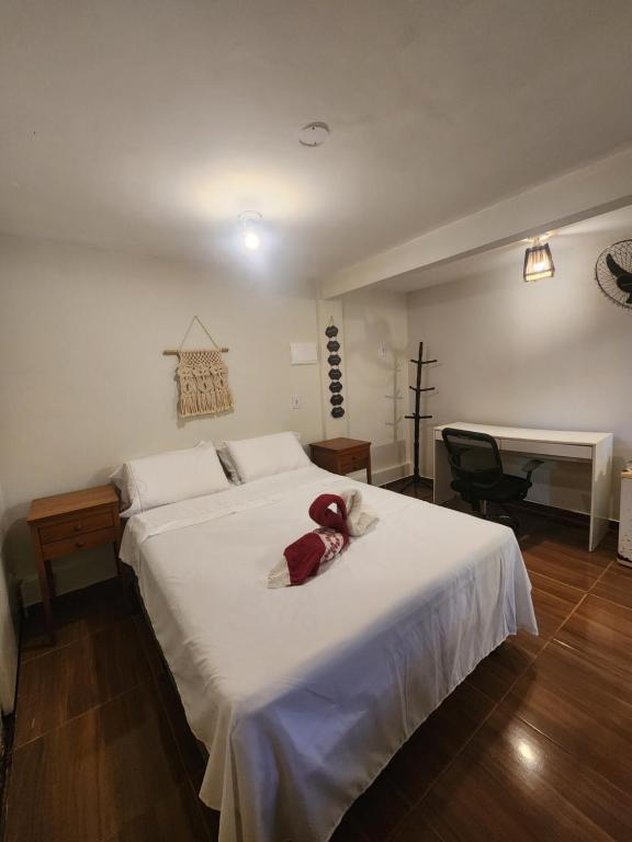 - une chambre dotée d'un lit blanc avec un animal rembourré dans l'établissement Loft Vista Mar, à Itacaré