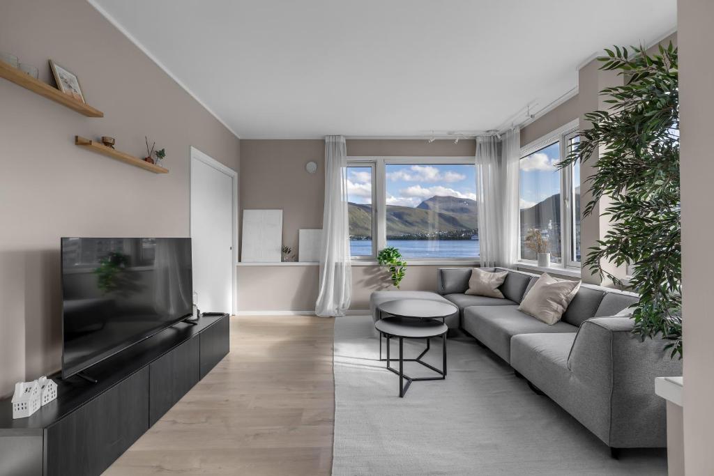ein Wohnzimmer mit Sofa und Fernseher in der Unterkunft Northstay - Tromsø Harbor Mountain View Apartment in Tromsø