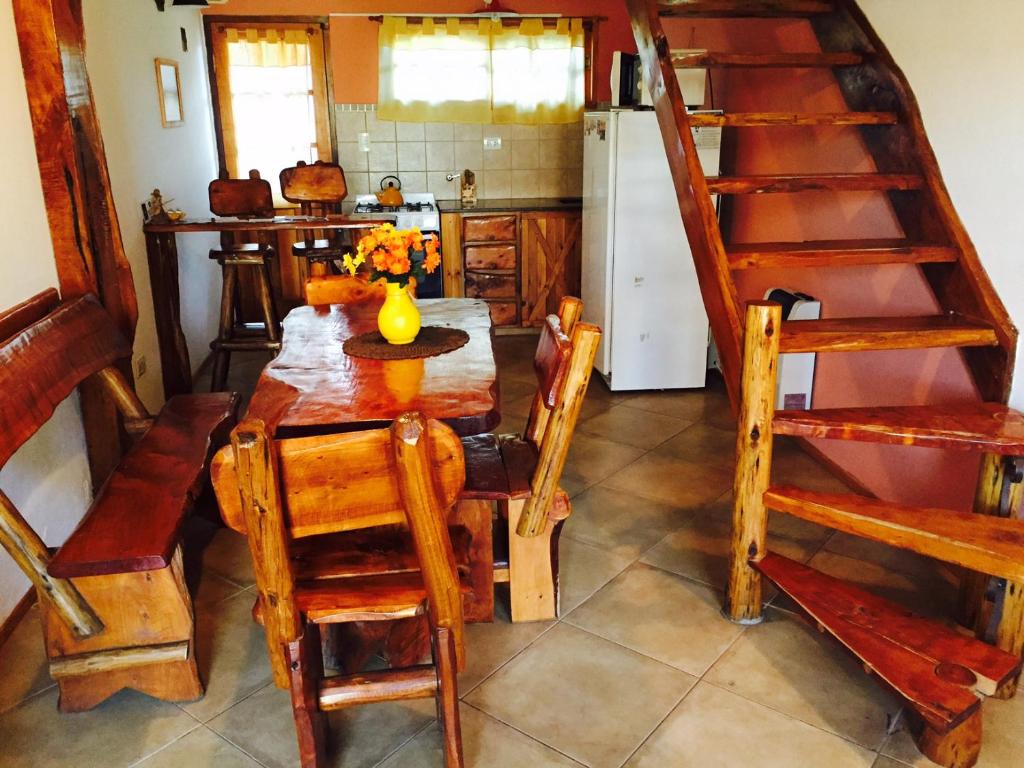 cocina con mesa de madera y nevera en Cabañas Playa del Sol en San Clemente del Tuyú