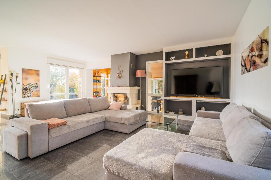 a living room with a couch and a tv at Castle view terrace - Swimming pool - Air conditioning in La Vancelle