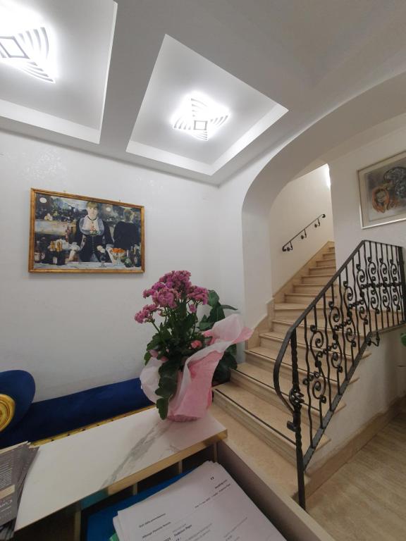 a staircase with a vase of flowers on a table at Albergo Flaminia Rooms Grottarossa in Rome