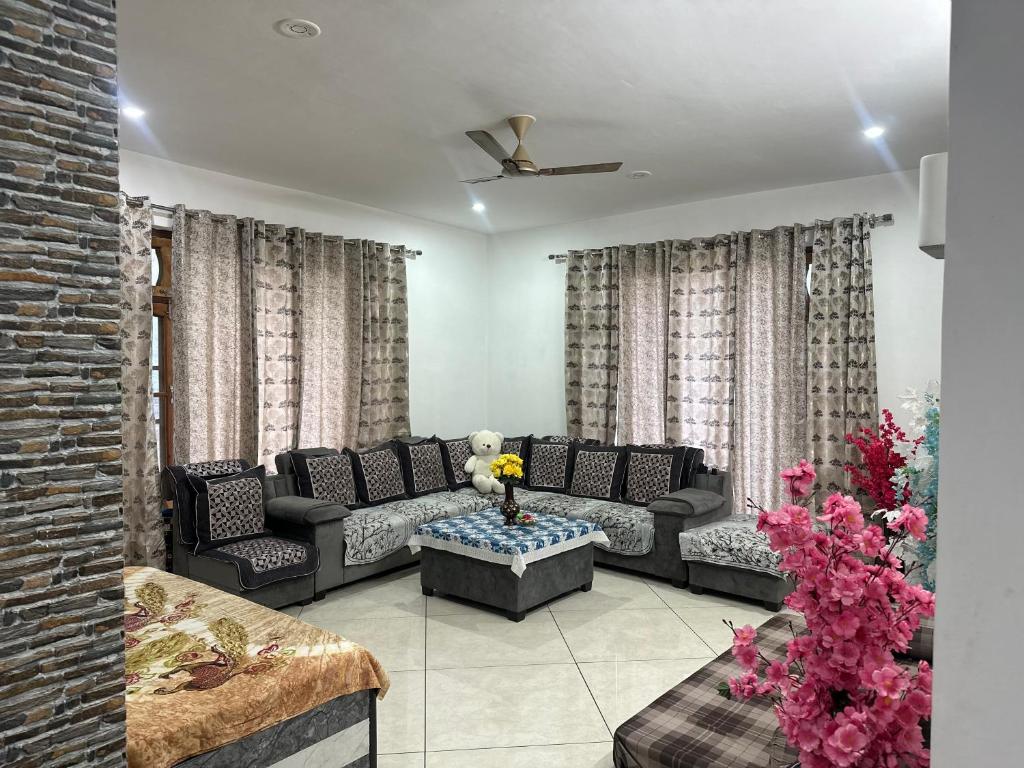 un soggiorno con un divano e un tavolo di Snower Valley homestay a Kulu