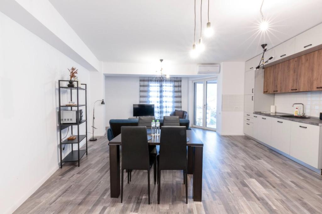 une cuisine et un salon avec une table et des chaises dans l'établissement City Center Accommodation - 505, à Reşiţa