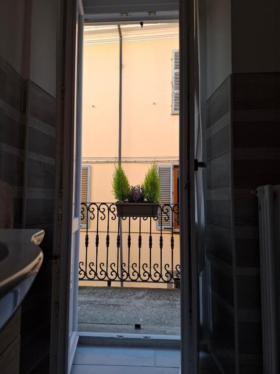 an open door to a balcony with a potted plant at La Casa Del Borgo in Torre Pellice