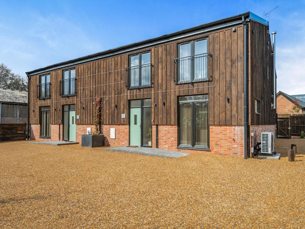a large wooden building with windows on a field at Old Barn 1 - Uk48477 in Ferndown