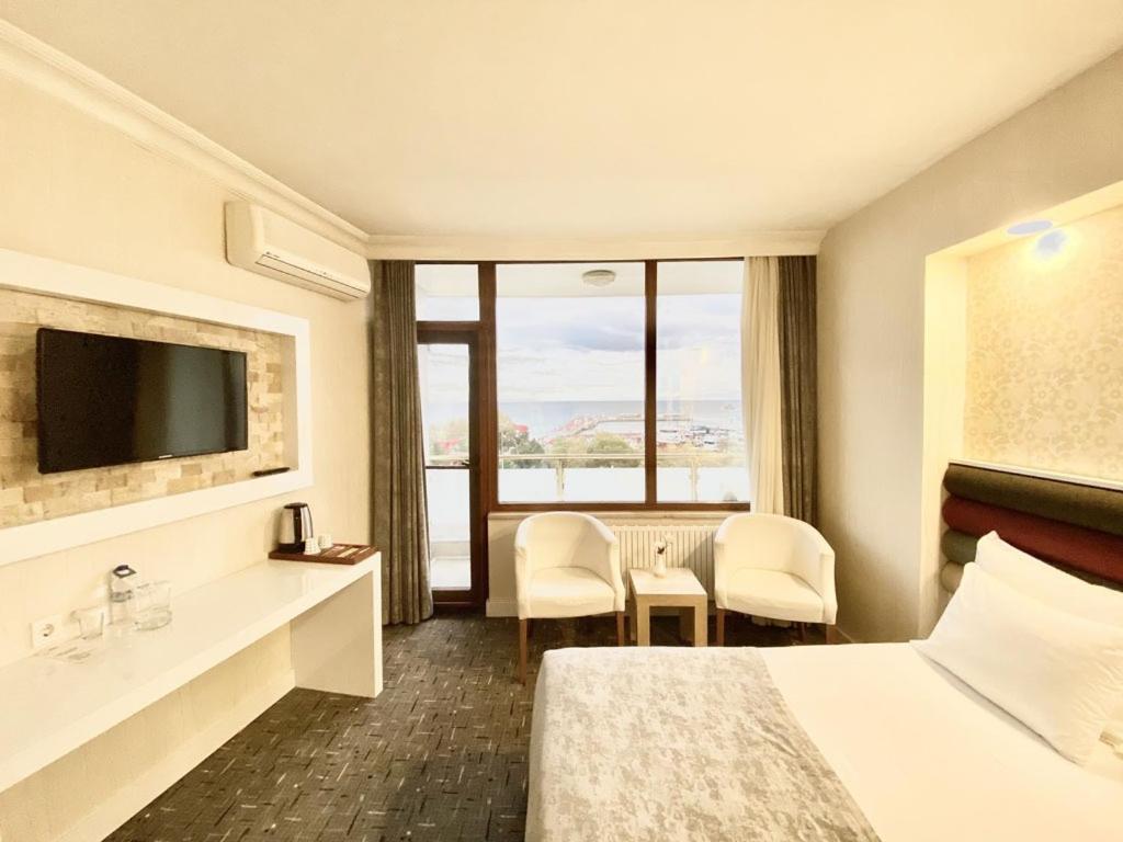 ein Hotelzimmer mit einem Bett und einem Fernseher in der Unterkunft Batın Hotel in Istanbul