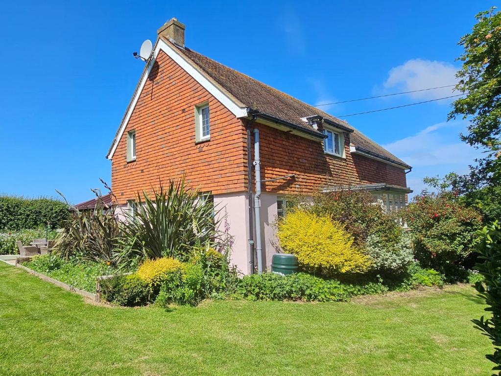 a brick house with a white garage in a yard at 3 Bed in Chale 94165 in Chale