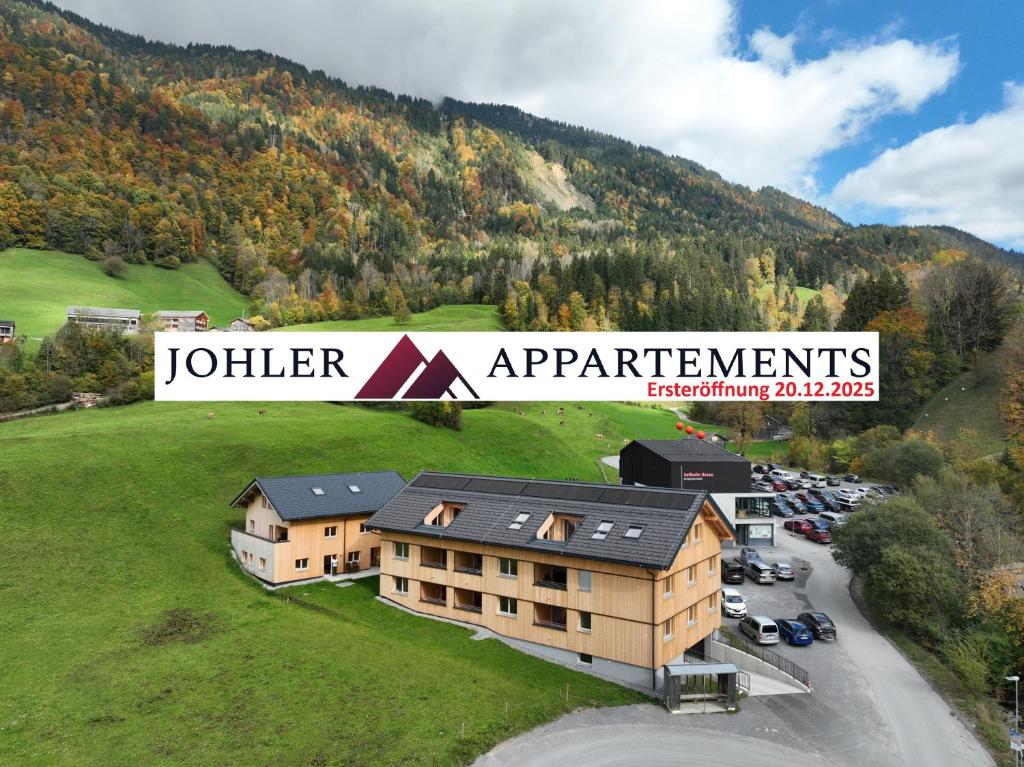 an aerial view of a hotel with a parking lot at Johler Appartements in Bezau