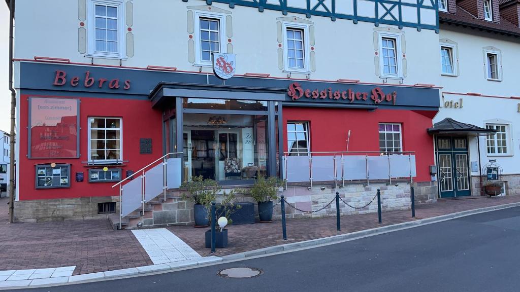 a red and white building on the side of a street at Hotel Bebra's Hessischer Hof in Bebra