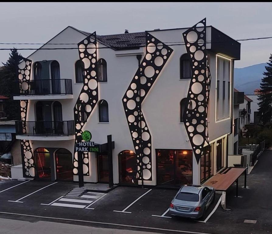 a building with a car parked in a parking lot at PARK INN, Bugojno in Bugojno
