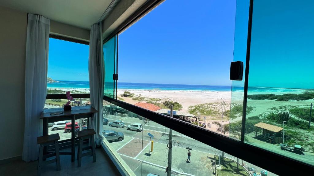 Una habitación con vista a la playa y al océano. en LOFT VISTA MAR - Orla da Praia Grande, en Arraial do Cabo