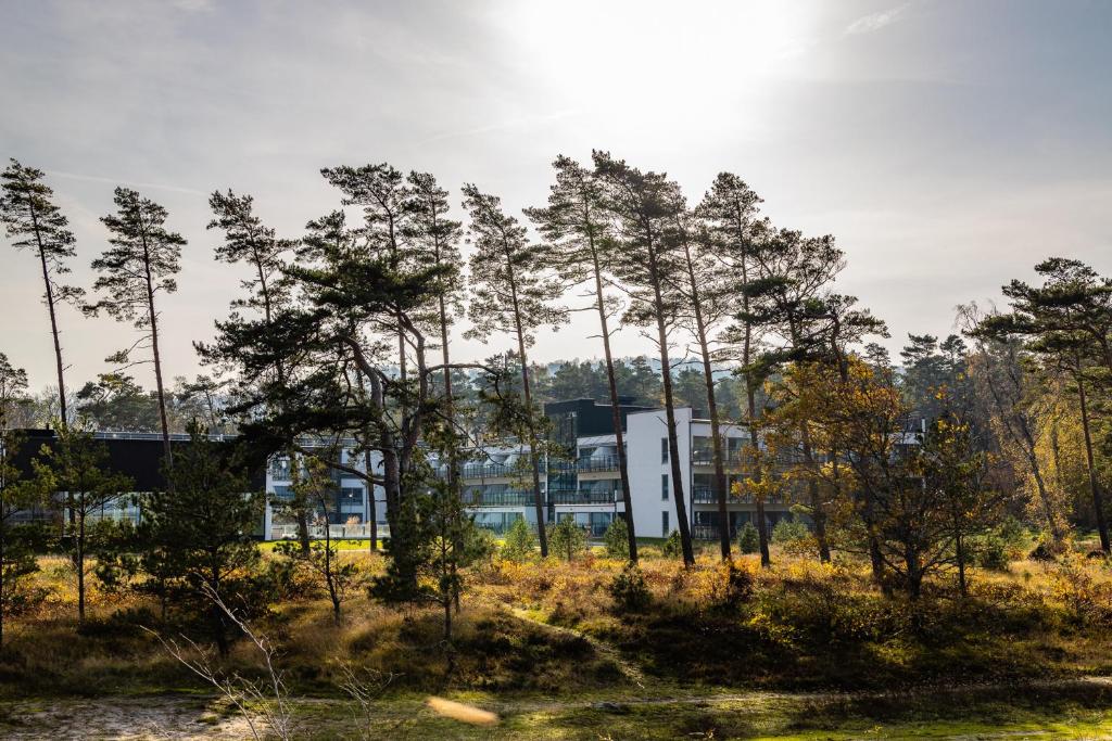 a building in the middle of a field with trees at Hotel Riviera Strand in Båstad