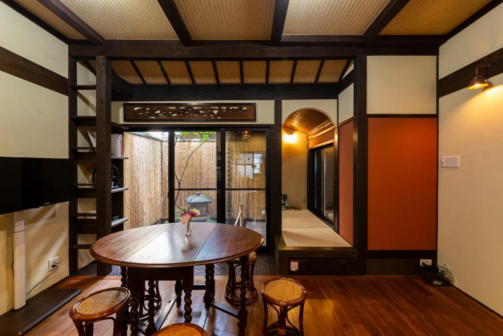 Una habitación con una mesa y sillas de madera y un espejo. en Shiori 栞 京都, en Kioto