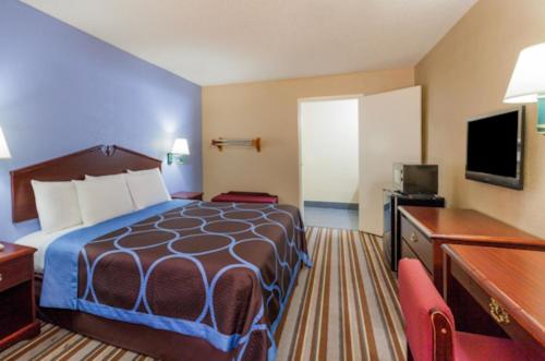 una camera d'albergo con un letto e una TV a schermo piatto di Mount Pleasant INN a Mount Pleasant