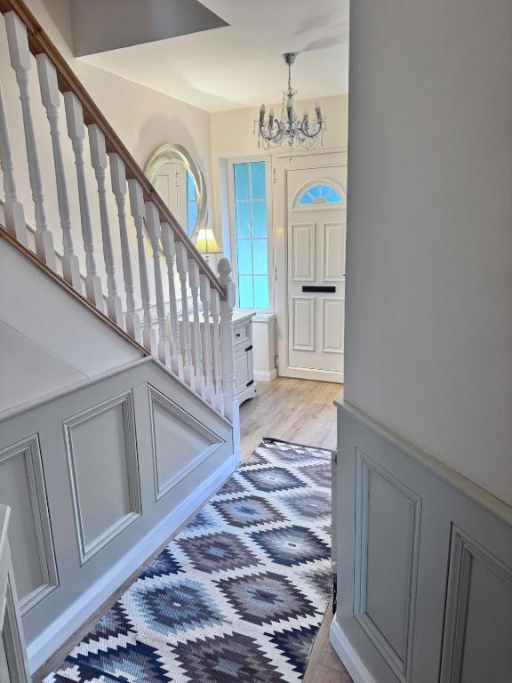 a hallway with stairs and a blue and white rug at Clones Town House in Cluain Eois