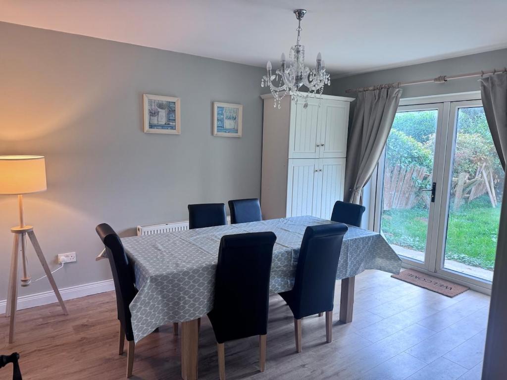 een eetkamer met een tafel en blauwe stoelen bij Clones Town House in Feevaghmore