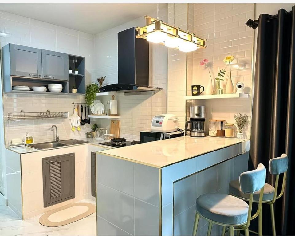 a kitchen with a counter and two stools in it at Peace Transit Hotel in Dar es Salaam