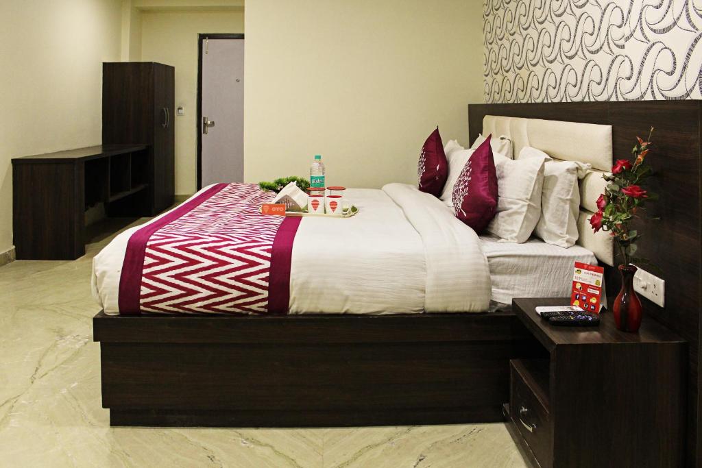 アグラにあるHotel O Tajway Innのベッドルーム1室(大型ベッド1台、赤と白の枕付)