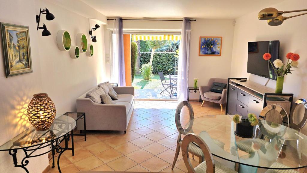 ein Wohnzimmer mit Sofa und Tisch in der Unterkunft Les Soleiades in La Londe-les-Maures