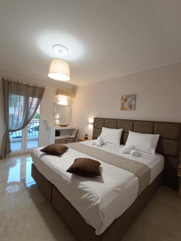 a bedroom with a large bed with white sheets at Roussa's Apartments in Laganas