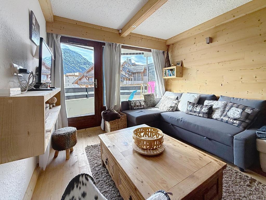 a living room with a blue couch and a table at La tanière des Chamois 7p - proche piste Chalvet in Montgenèvre