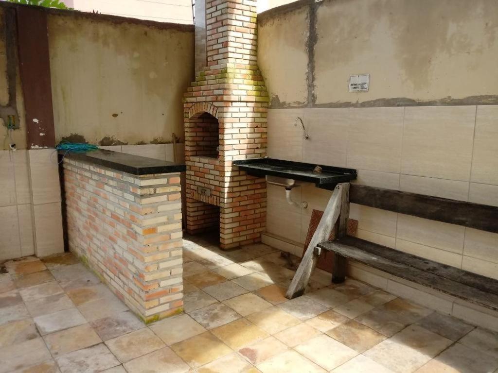 a brick oven in a room with a bench at Condomínio tropicaliente in Caucaia