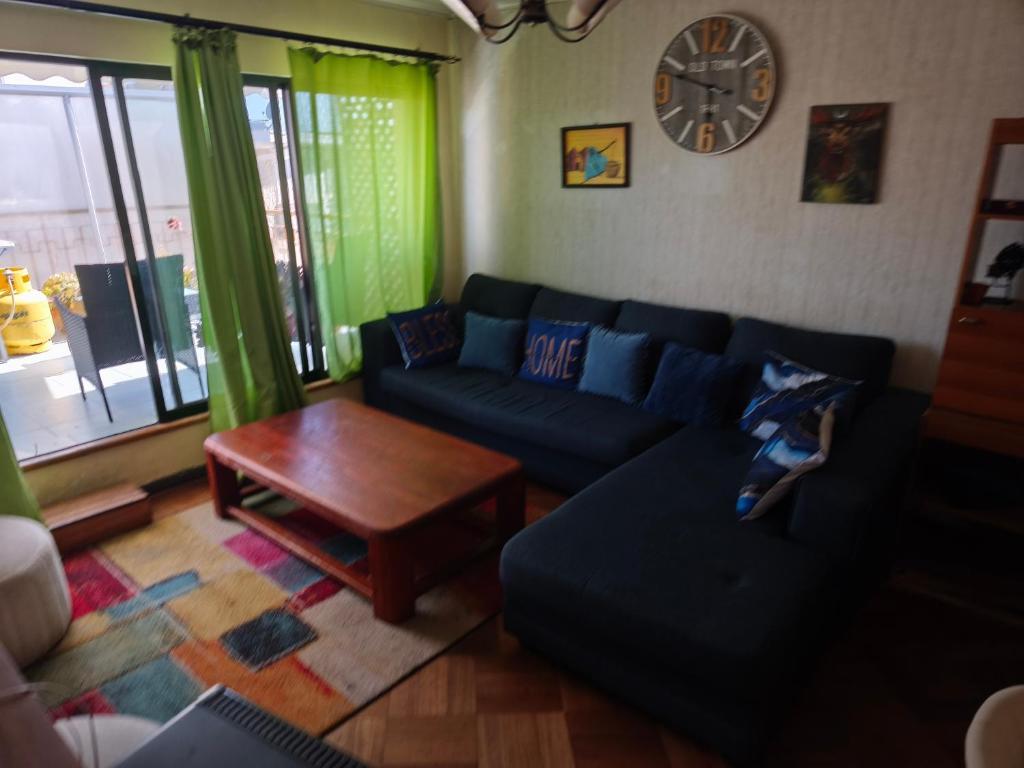 a living room with a blue couch and a table at A pasos de la playa in Algarrobo