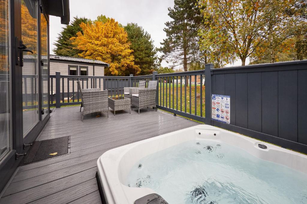 a hot tub on the deck of a house at Royal Pines Lodge with Hot tub in Allerthorpe