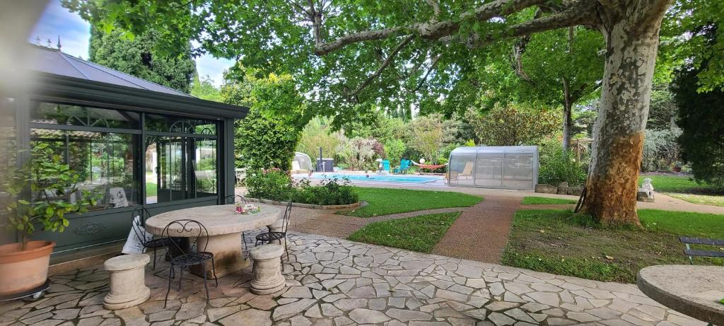 a house with a picnic table in a park at Maison charmante au Thor + Piscine in Le Thor